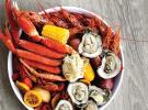 a steamer platter features gulf shrimp, a clab cluster, oysters, mussels, and hot-boiled crawfish with corn.