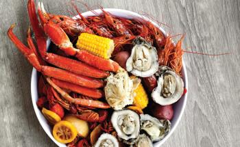 a steamer platter features gulf shrimp, a clab cluster, oysters, mussels, and hot-boiled crawfish with corn.